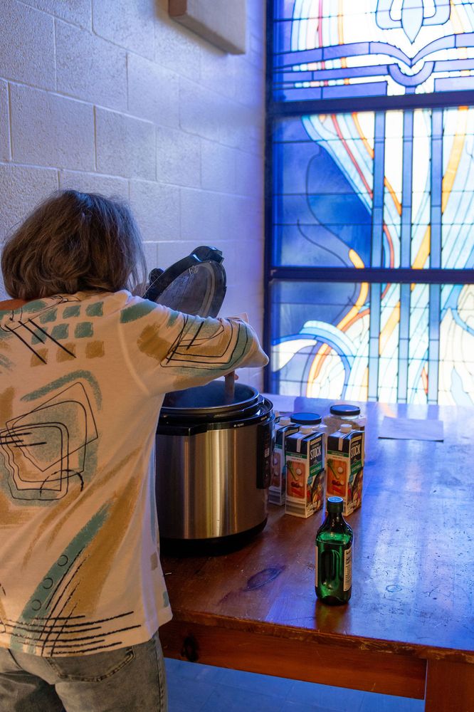 A volunteer setting up by the hall's stained-glass windows