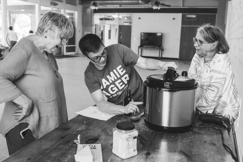 Neighbors served from slow cookers at a community meal